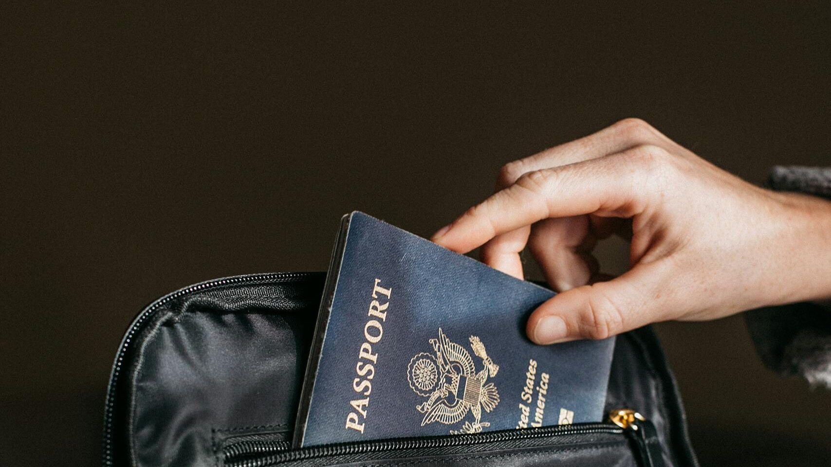 Person Putting a Passport on Bag